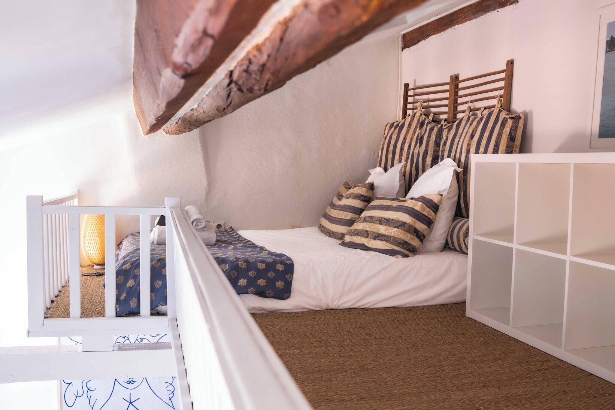 A child's bedroom with a bunk bed, a white crib, and a white storage unit.