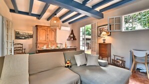 Una sala de estar acogedora con un sofá, armarios de madera y un comedor.