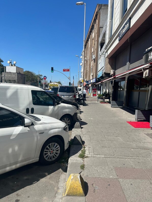 A street with parked cars and a building with a sign that reads "JOI Suites". - Joi Suite Hotel (İstanbul)