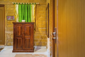 Un gabinete de madera con una cortina verde, un cuadro en la pared y una puerta a la derecha.