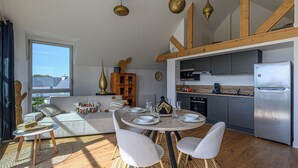 A modern kitchen with a built-in oven and a stainless steel refrigerator.