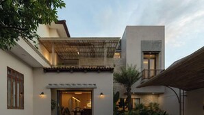 A modern building with a covered patio, a stone facade, and a well-lit entrance.