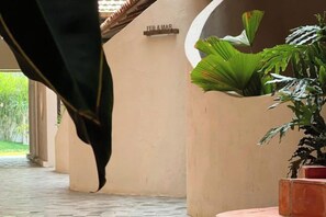 A corridor with a potted plant and a sign indicating 'FEB & MAR'. - Moonlight Homestay & Garden (P. Thong Nhat)