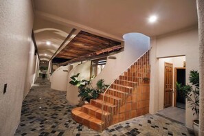 A staircase with a wooden handrail and steps, leading to a landing with a door. - Moonlight Homestay & Garden (P. Thong Nhat)