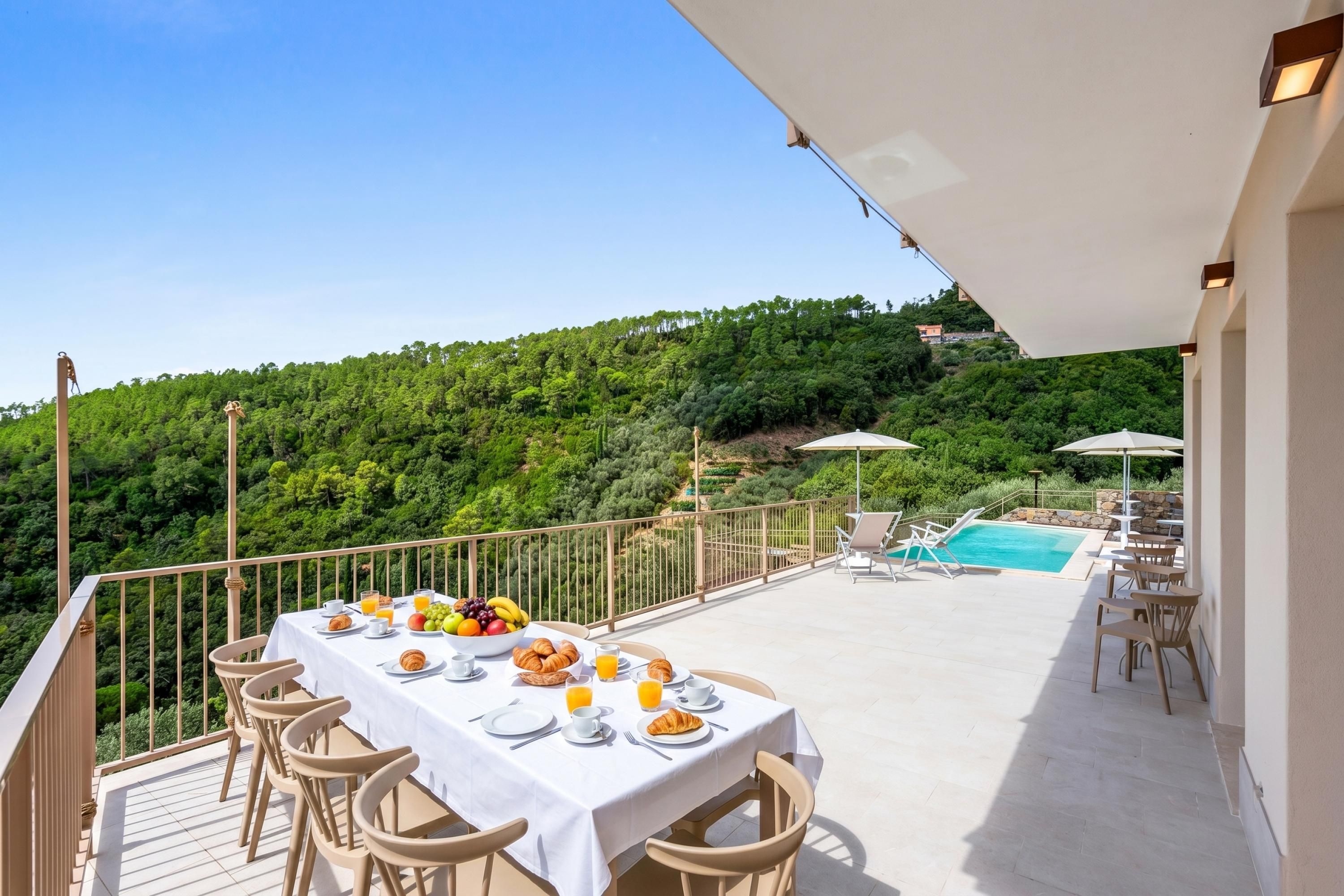 Una mesa de comedor dispuesta con alimentos para el desayuno, una piscina y una vista panorámica a una colina.