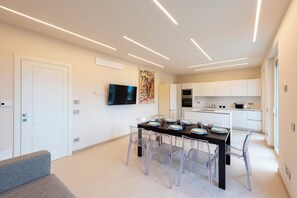 A modern kitchen with white cabinets, a black countertop, and a built-in oven. - Relais Le Torri in Verici (Casarza Ligure)