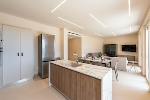 A modern kitchen with a marble countertop, stainless steel appliances, and a built-in wooden cabinet. - Relais Le Torri in Verici (Casarza Ligure)