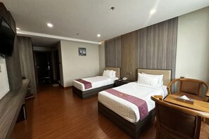 A hotel room with two beds, a wooden desk, a TV, and a view of the hallway. - Golden Arrow Hotel (Botataung)
