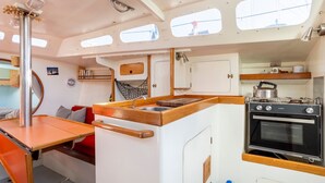 A compact galley with a sink, stove, and storage cabinets. - Sailing Boat 'Voilier Pyman - Le Chant Des Voiles' with Sea View and Private Terrace (Douarnenez)