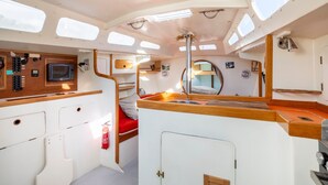 A compact galley with a microwave, control panel, and a small sink. - Sailing Boat 'Voilier Pyman - Le Chant Des Voiles' with Sea View and Private Terrace (Douarnenez)