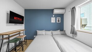 A modern bedroom with a bed, a desk, and a TV displaying 'NETFLIX'. - CHARMANT 1A (Minamifurano)