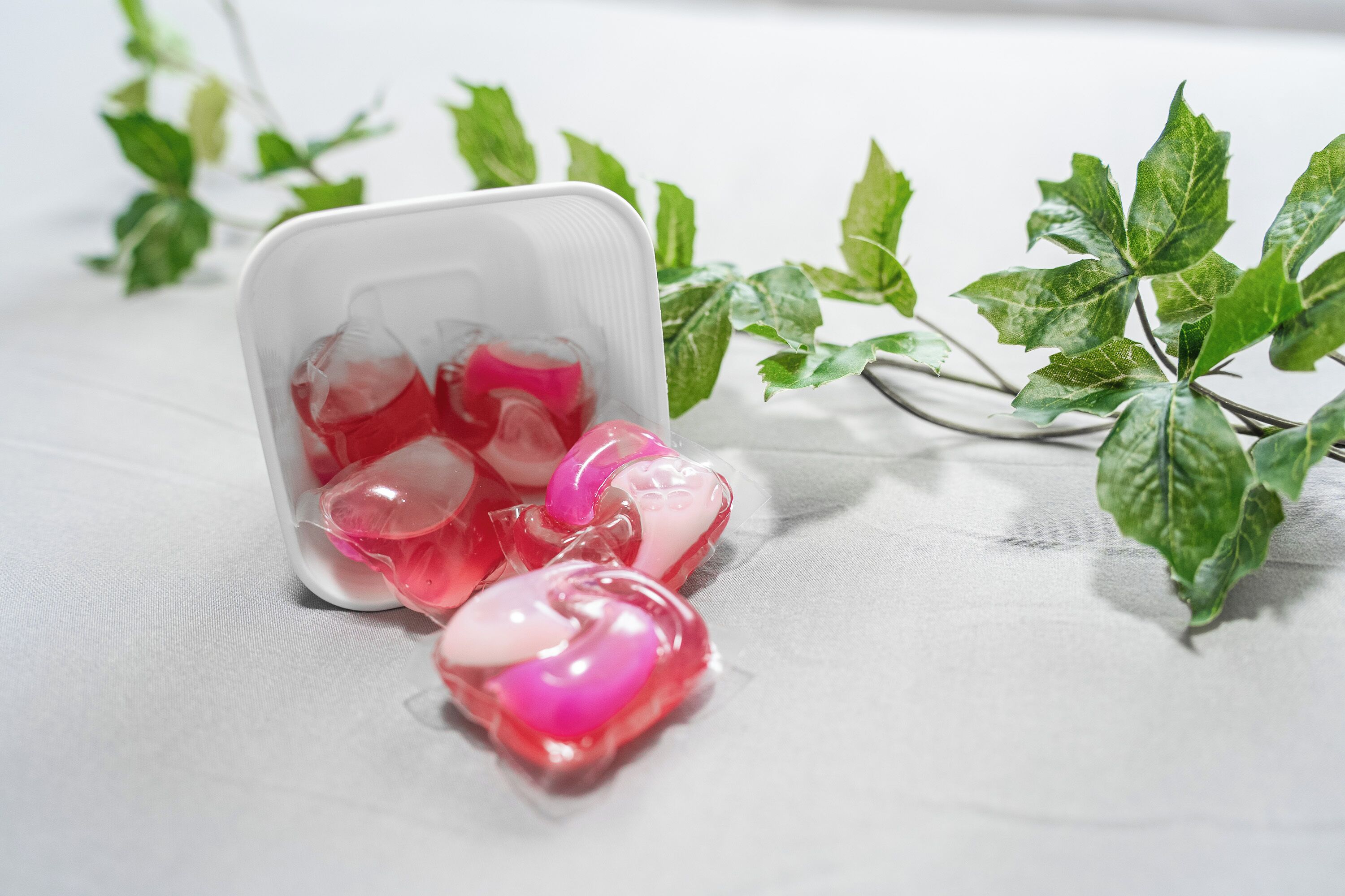 Een witte plastic bak met een hartvormig voorwerp en een roze object op een witte ondergrond.
