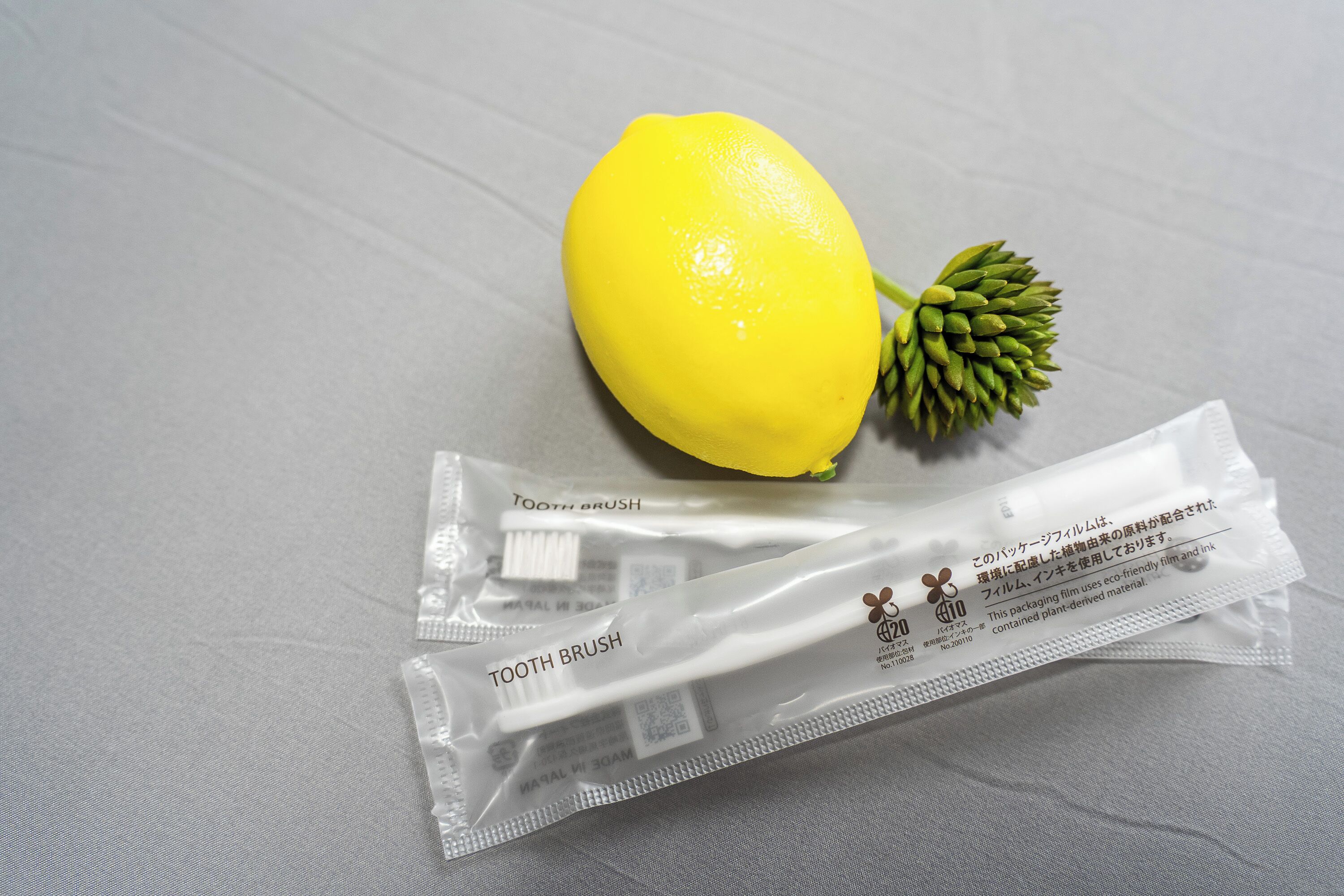 Un limón y dos paquetes de cepillos de dientes sobre una mesa.