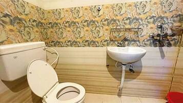 A bathroom with a toilet, sink, and floral-patterned walls.