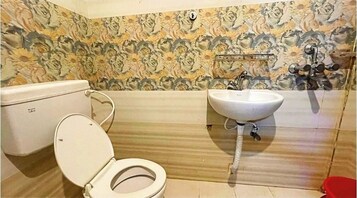 A bathroom with a toilet, sink, and floral-patterned walls.