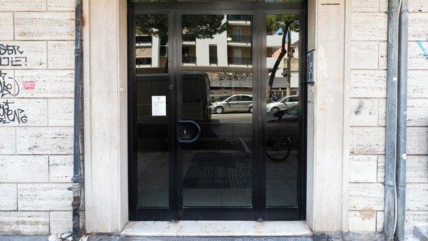 A building entrance with a glass door, a visible number '25' on the wall, and a brick facade. - Casina del Parco by Wonderful Italy (Bari)