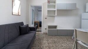 A modern living room with a grey sofa, a small table, and built-in shelving. - Casina del Parco by Wonderful Italy (Bari)