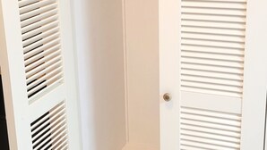 Ein weißer Schrank mit Ablagefläche und Tür.