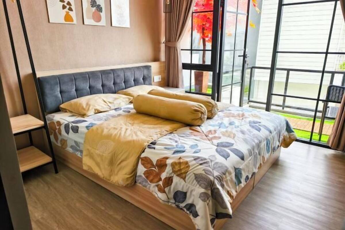 Une chambre à coucher avec un lit, une table de chevet, une fenêtre avec des rideaux et une vue sur l’extérieur.