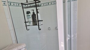 A bathroom with a shower, tiled floor, and a shelf with toiletries. - Direct water front 3 meters from Lake.
Your own private balcony overlooking Lake (Fennell Bay)