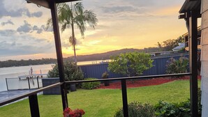 A wooden deck with a view of a body of water and a sunset. - Direct water front 3 meters from Lake.
Your own private balcony overlooking Lake (Fennell Bay)