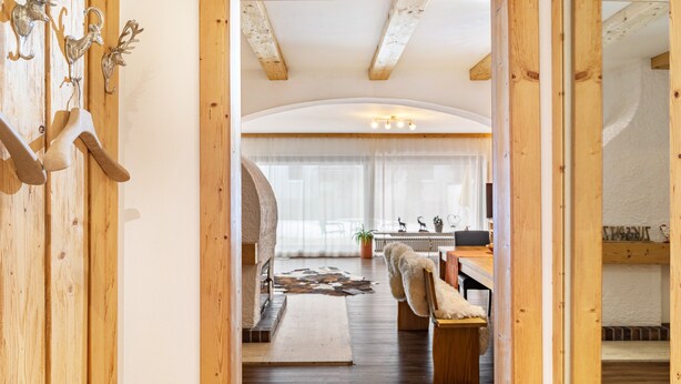 A wooden interior with a rustic design, including a coat rack with antlers and a fur throw. - Apartment 'Bergwild' with Mountain View, Private Terrace and Wi-Fi (Garmisch-Partenkirchen)