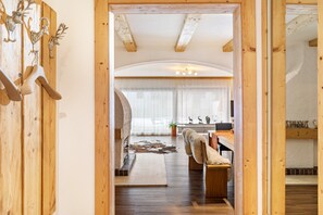 Un interior de madera con un diseño rústico, que incluye un perchero con cuernos de ciervo y una manta de piel.