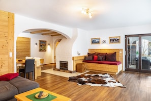 Una sala acogedora con chimenea, muebles de madera y un ventanal grande.