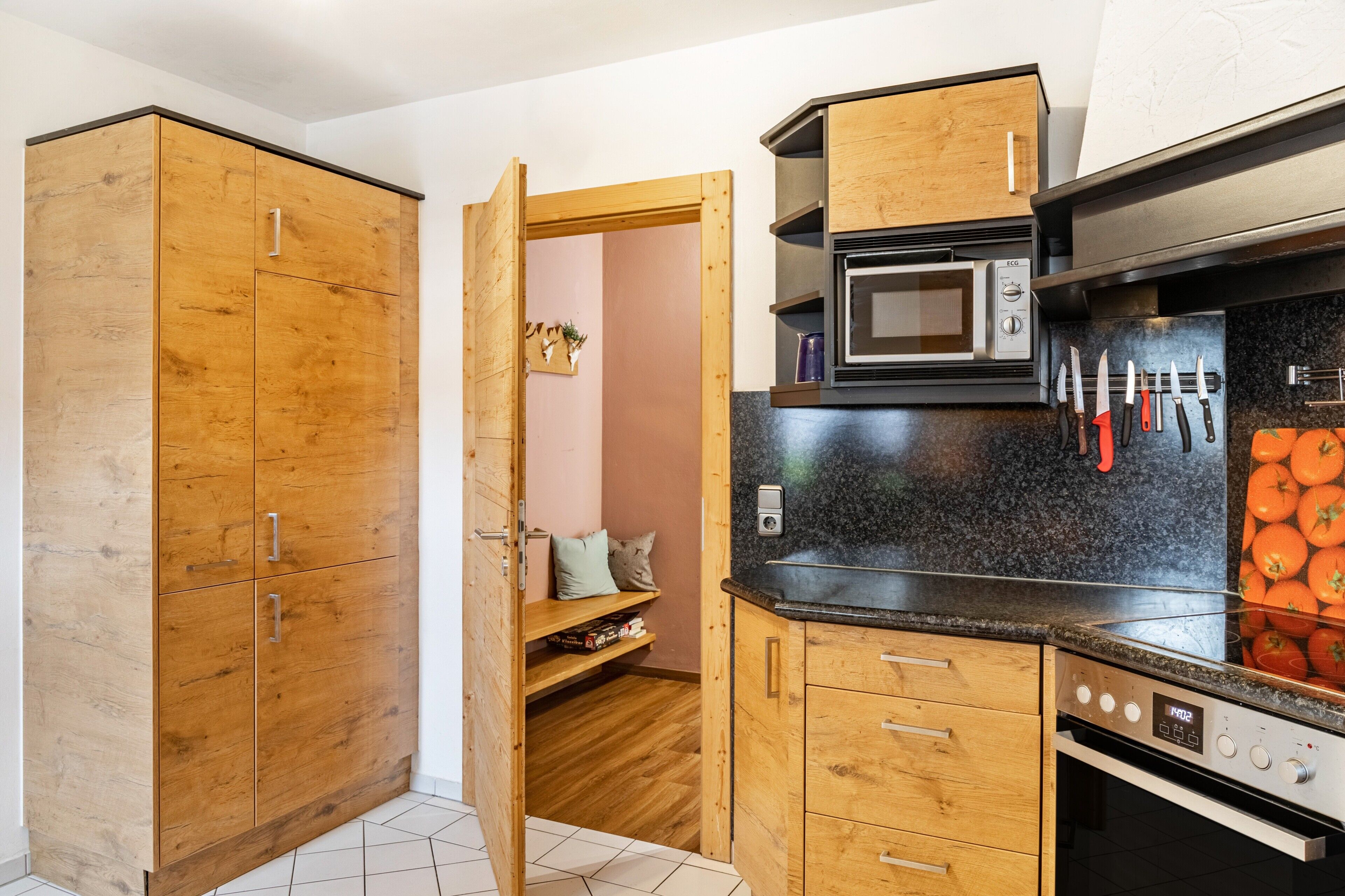 A compact kitchen with wooden cabinets, a microwave, and a stove.