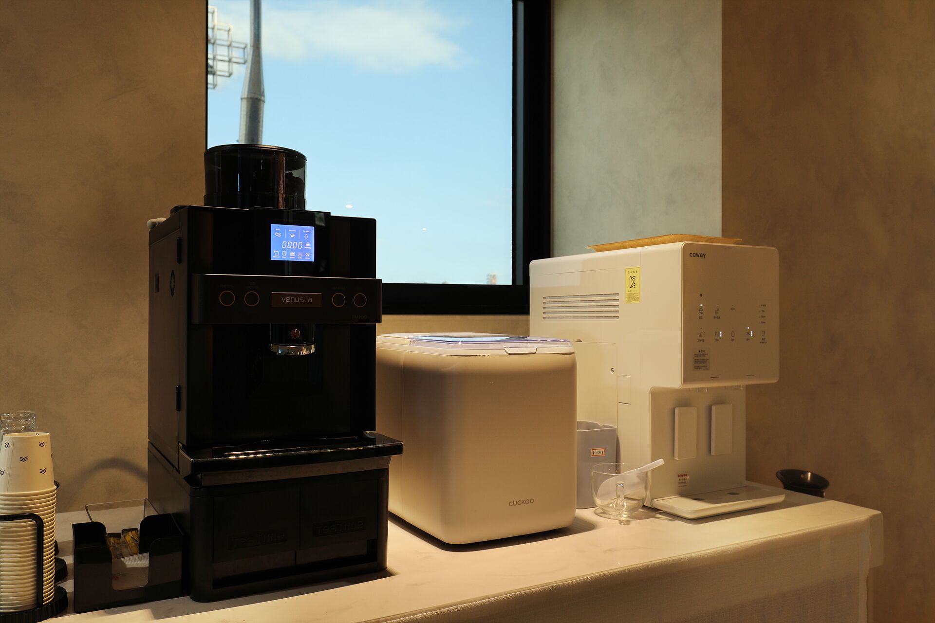 Una cafetera, un dispensador de agua y un vaso sobre la encimera.