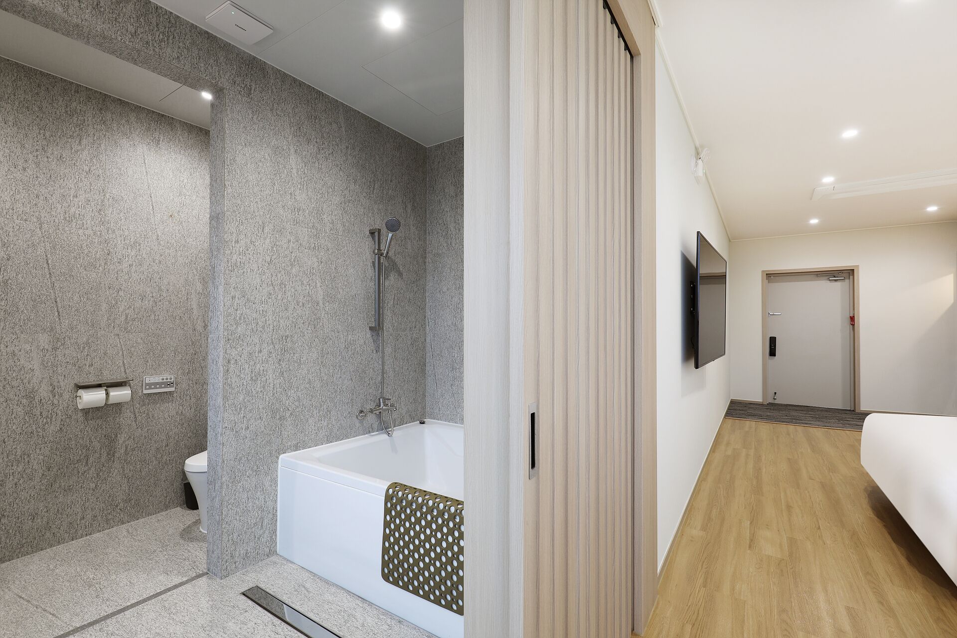 A modern bathroom with a shower, toilet, and bathtub.