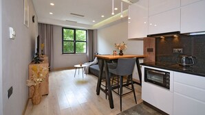 Una cocina moderna con zona de comedor, una cafetera y un ventanal grande.