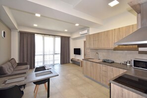 Apartamento básico, balcón, vistas a la ciudad | Zona de estar | Televisión de pantalla plana de 50 pulgadas con canales por cable