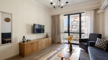 Apartament tradicional, balcó, vistes a la ciutat | Sala d'estar | Televisor de pantalla plana de 50 polzades amb canals per cable