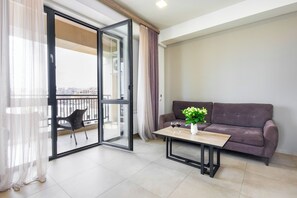 Leilighet – executive, balkong, byutsikt | Oppholdsområde | En 50-tommers Flatskjerm-TV med kabel-kanaler