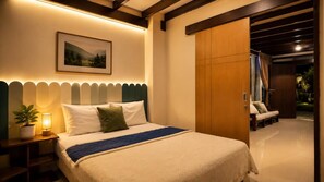 Una habitación de hotel con cama, mesita de noche, lámpara y vistas al exterior.