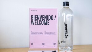 Een welkomstpakket, een waterfles en een pen op een tafel.