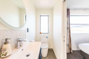 A hotel bathroom with a sink, toilet, and a window. - 37 Galaxy B (Lake Tekapo)