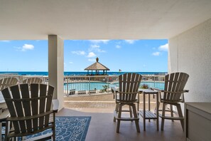 Ein Balkon mit Adirondack-Stühlen, einem Pool und Blick aufs Meer.