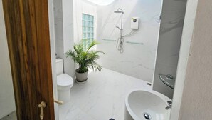 A modern bathroom with a shower, toilet, and sink.