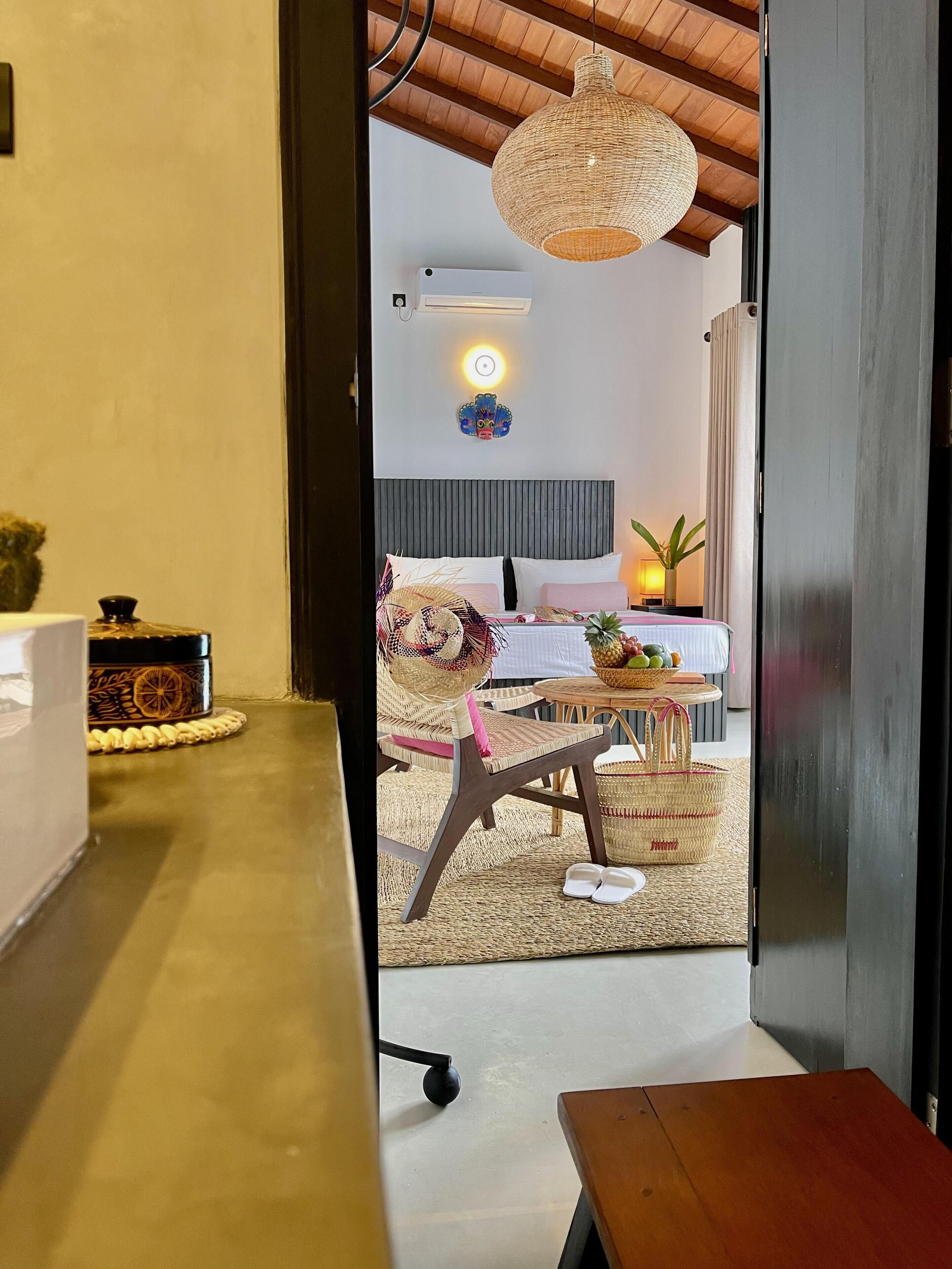 Ein Hotelzimmer mit einem Bett, einem Nachttisch und einem Korbstuhl.