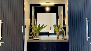 A modern bathroom with a dark wood vanity, a mirror, and two potted plants. - D' Art Villa Retreat and Spa (Tangalle)
