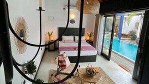 A bedroom with a bed, bedside tables, a hanging light fixture, and a view of a swimming pool. - D' Art Villa Retreat and Spa (Tangalle)