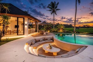 A modern outdoor living area with a pool, a curved seating area, and a glass-enclosed structure. - Villa Vidrev - Private Infinity Pool & Rice Fields by BaliSuperHost (Bali)