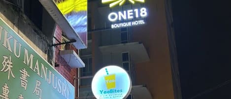 A building with signs for 'ONE18 Boutique Hotel' and 'YaoBites'.
