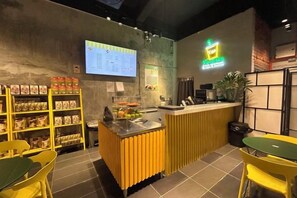 Interno di un ristorante con bancone, zona con posti a sedere e esposizione del menu.