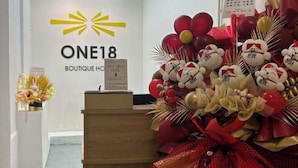 A reception area with a sign for 'ONE18 Boutique Hotel' and a decorative arrangement of balloons and plush toys. - ONE18 Boutique Hotel (Kuala Lumpur)