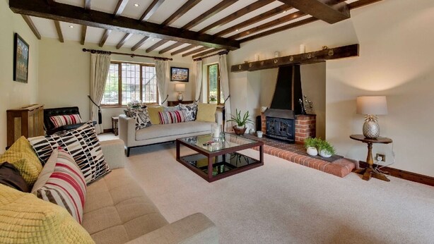 A cozy living room with a fireplace, a sofa with patterned cushions, and a coffee table.