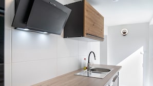 Una cocina moderna con estufa integrada, pileta y muebles de madera.