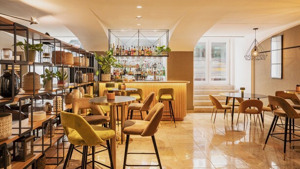 Eine moderne Bar mit verschiedenen Sitzgelegenheiten und einer gut sortierten Spirituosenpräsentation.
